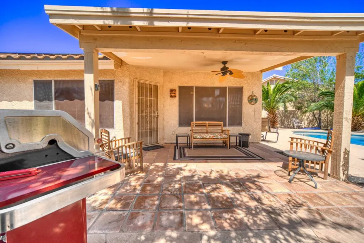 This scene features a grill, a cozy seating area, and a shimmering swimming pool, all set within a private outdoor retreat. The space suggests opportunities for socializing, al fresco dining, and relaxing in style after a round of golf.